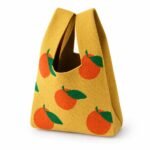 Bolso de mano amarillo con naranjas
